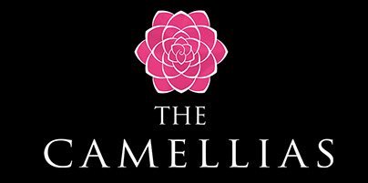 Stylish pink floral logo for The Camellias housing community on black background.